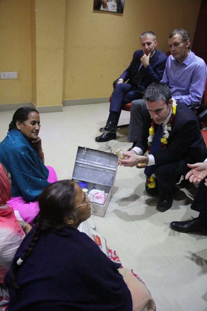 Minister looks at the contents of a Community Health Volunteer’s medicine box