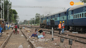 People sitting on the railway tracks at Mayapuri slum