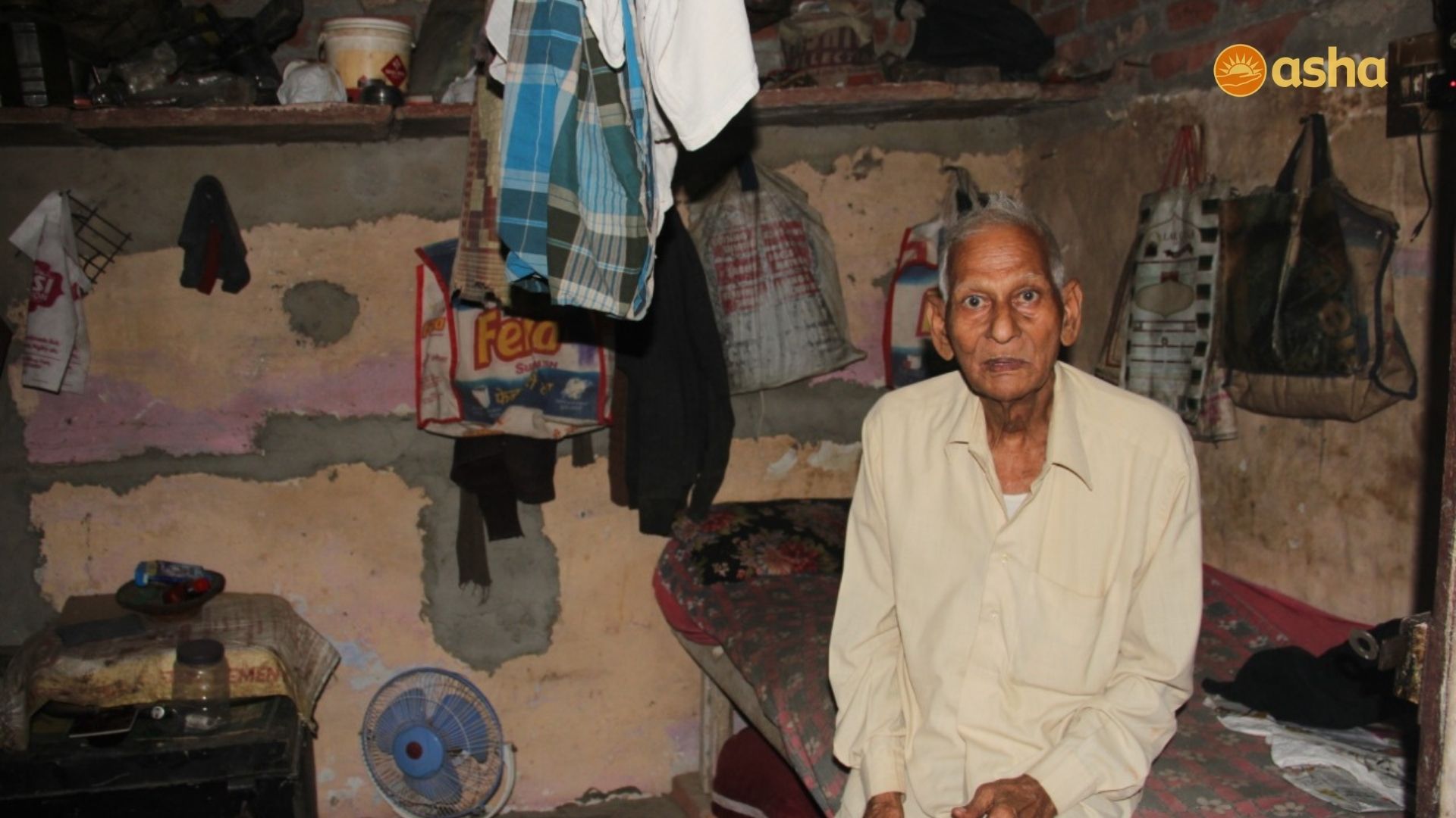 Elderly man living alone in the slums cared for by Asha