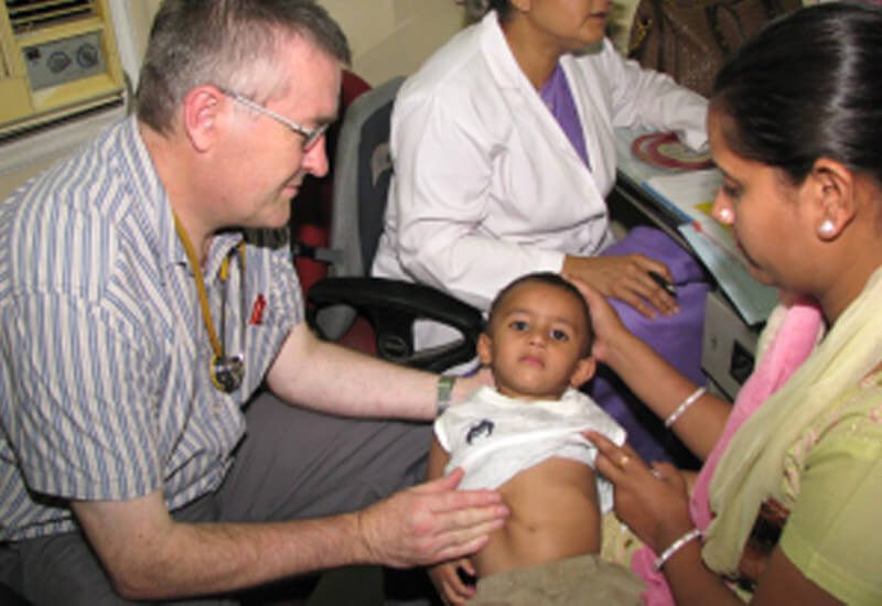 Dr Richard Hogben from the UK examining a child at the Asha Polyclinic