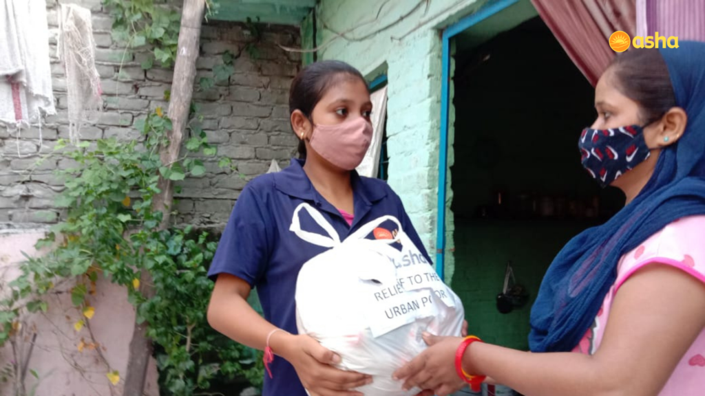 Asha warrior providing groceries to the needy at Asha community